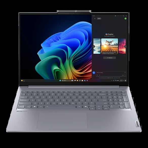 Silver laptop displaying colorful Windows 11 wallpaper with abstract swirling blue, green, and orange design on screen
